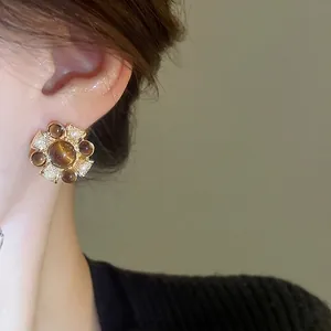 Vintage gold flower earrings with brown stones and white pearls on female model ear