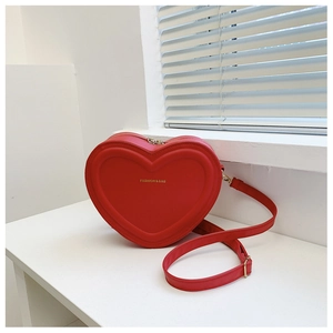 Dettaglio macro della borsa in pelle rossa a forma di cuore con testo Fashion & Bag e texture