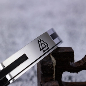 Minimalist silver stainless steel open bangle with engraved geometric band logo