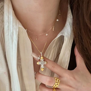 Detail of Vatican cross pendant and gold layered necklace with sparkling zircons