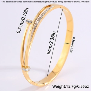 Detail of gold Mobius bangle featuring crystal-studded nail design and polished finish