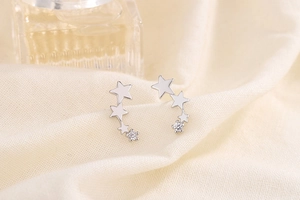 Close-up of triple star S925 silver stud earrings with sparkling cubic zirconia stones