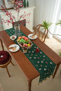 Deep green Christmas table runner with Santa patterns and elegant tassel detail