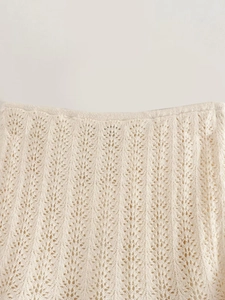 Dettaglio del tessuto a maglia panna con intricati motivi a onde traforati