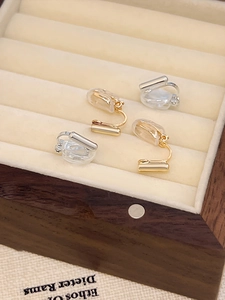 Close-up of gold and silver adjustable spiral ear clip converters with silicone pads