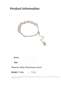 Detailed view of silver charm bracelet featuring synthetic cat eye stones and heart pendant