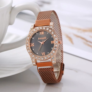 Montre pour femme en or rose avec lunette diamantée et bracelet magnétique sur marbre
