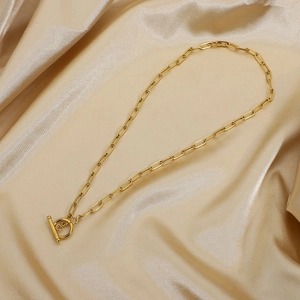 Golden paperclip link chain necklace with classic toggle OT clasp on satin background