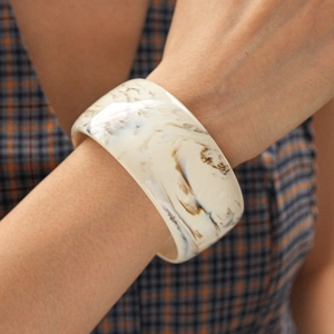 Close-up of marble pattern resin bangle bracelet on female wrist with retro clothing