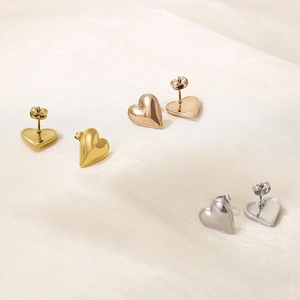 Close-up of 3D heart studs in gold, silver, and rose gold with polished finish