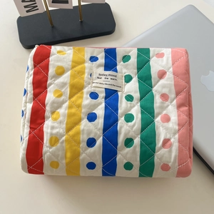 Dettaglio del beauty case in cotone trapuntato con righe arcobaleno e pois colorati