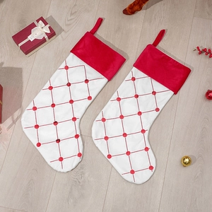 Dettaglio calze di Natale in velluto rosso e bianco con paillettes su pavimento in legno