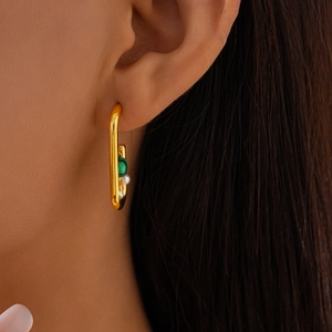 U-shaped gold earrings with malachite and pearl on model's ear for elegant look