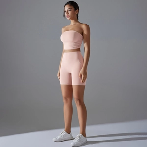Detail view of pink seamless two-piece yoga set with ruched sports top and high waist shorts