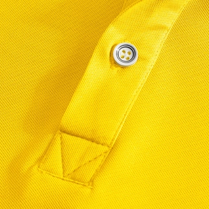 Macro shot of yellow pique polo shirt showing reinforced placket and button stitching