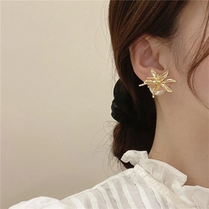 Detailed side view of a gold-plated flower stud earring featuring a large pearl back closure