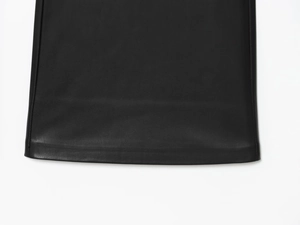 Detailed view of the smooth edge stitching and fine grain texture on black leather pants