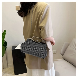 Dettaglio dell'elegante borsa a conchiglia nera con strass scintillanti e chiusura a bacio