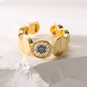 Retro 18K gold plated evil eye open ring with blue zircons on white stone background