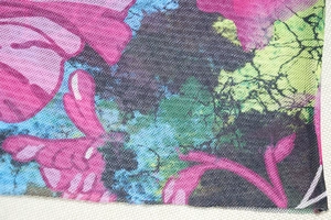 Detail of breathable mesh fabric with abstract floral print in pink, blue and green hues
