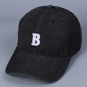 Detail of black denim baseball cap with white embroidered B and original hanging tag