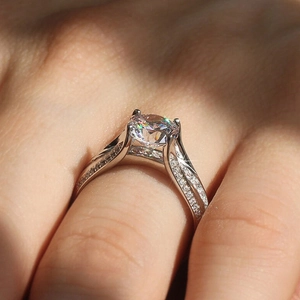 Detailed macro view of four-prong setting with round diamond and side pavé accents