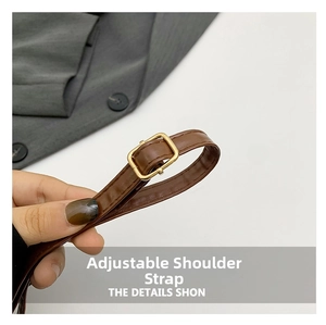 Détail d'une bandoulière réglable en cuir marron avec boucle dorée polie sur un sac femme
