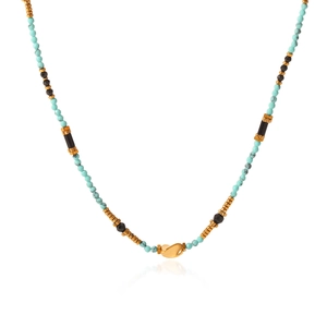 Close-up of bohemian beaded necklace with turquoise stones and gold-plated center pendant