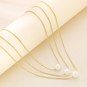 Three-layer gold snake chain necklaces with white pearl pendants in minimalist style