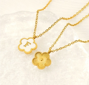 Detail of 18K gold clover necklace with shell inlay and custom letter F engraving