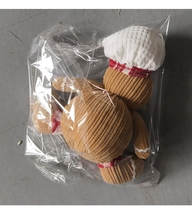 Detailed view of plush gingerbread man with white chef hat and textured corduroy fabric