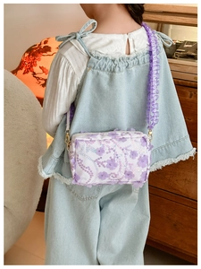 Detail of floral crossbody bag with 3D lavender flowers and pleated purple strap
