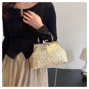 Detail of champagne gold sequined evening bag with embroidery on a model