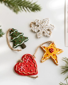 Macro shot of four gingerbread-style Christmas tree ornaments with rustic hemp strings