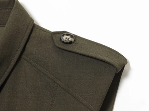 Detail of shoulder epaulette on army green dress with tortoiseshell button and twill texture