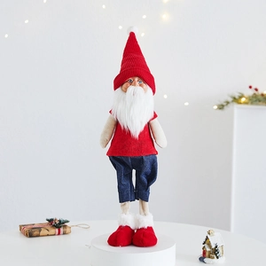 Detail of a Christmas gnome plush with a red knitted hat and white beard on a white base