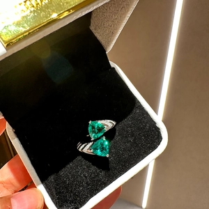 Detailed macro view of silver open ring with dual green triangle zircon stones