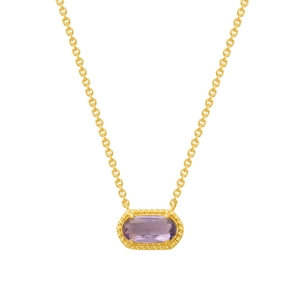 Macro detail of gold necklace with oval purple gemstone pendant and beaded golden border