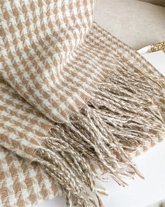 Close-up of khaki houndstooth scarf showing soft cashmere-like texture and fringe trim