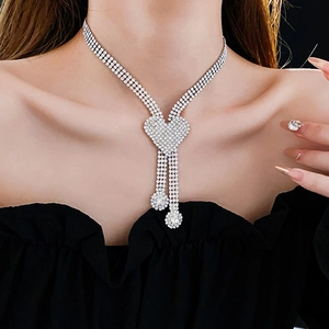 Close-up of sparkling silver heart pendant necklace with rhinestones on model neck