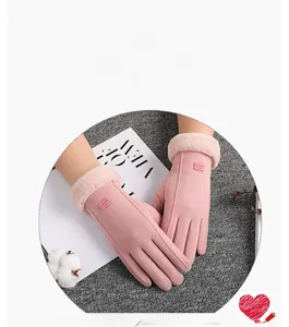 Detail view of pink suede winter gloves with plush cuffs and touch screen fingertips