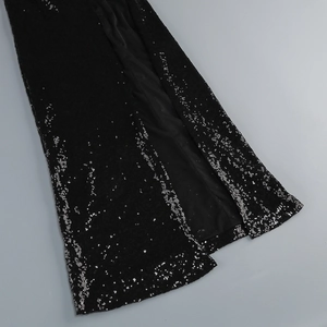 Detailed close-up of side slit design on a black sequin dress with mesh lining