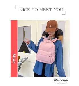 Detail view of pink canvas backpack with cute rabbit ears worn by a model