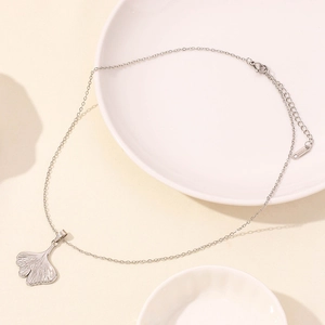 Detail of silver ginkgo leaf pendant on a stainless steel chain with lobster clasp