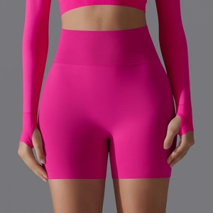 Detail of rose red seamless yoga set featuring ribbed high waist shorts and thumbhole sleeves
