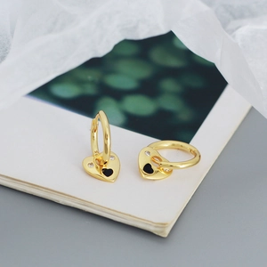 Macro view of 925 silver gold heart hoop earrings with black enamel and zircons