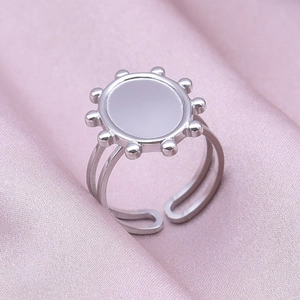 Macro shot of silver stainless steel geometric oval ring with smooth sun-shaped center surface