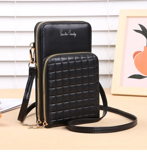 Detail of black PU leather crossbody bag featuring checkered pattern and gold zippers
