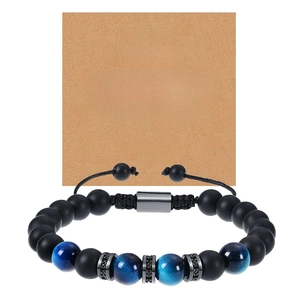 Détail du bracelet en perles noires mates et œil de tigre bleu avec carte cadeau