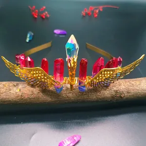 Detailed shot of handmade crystal crown headband with golden wings on dark wood branch